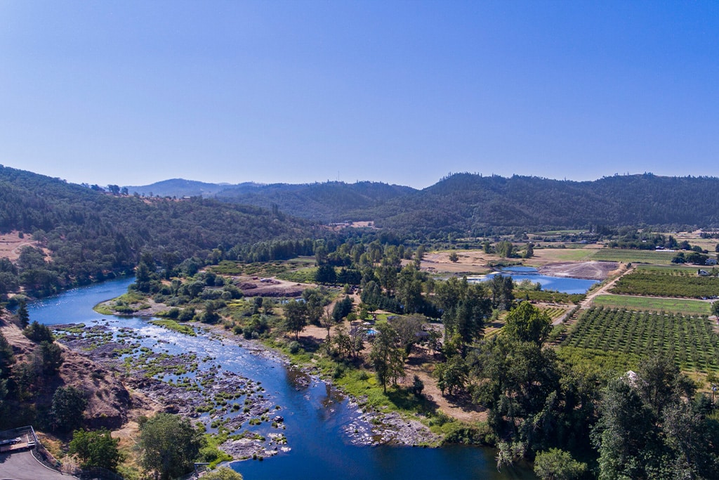 aerial view of campground with mountains in the background and a river flowing through